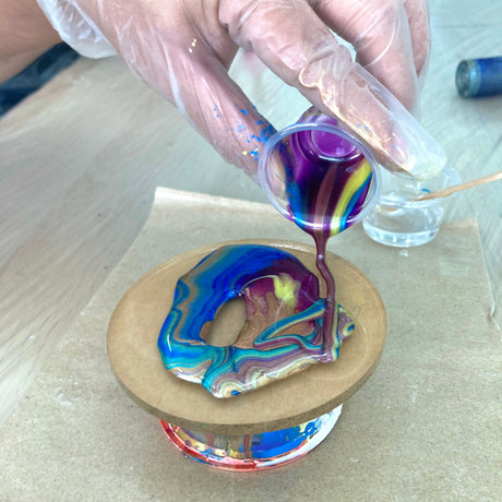 Artist pouring colorful resin for a UV resin and epoxy resin comparison